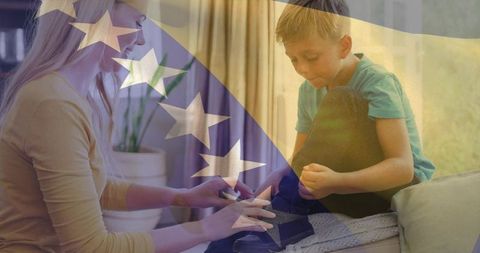 Helping child fastening sneaker at home with bosnia and herzegovina flag overlay