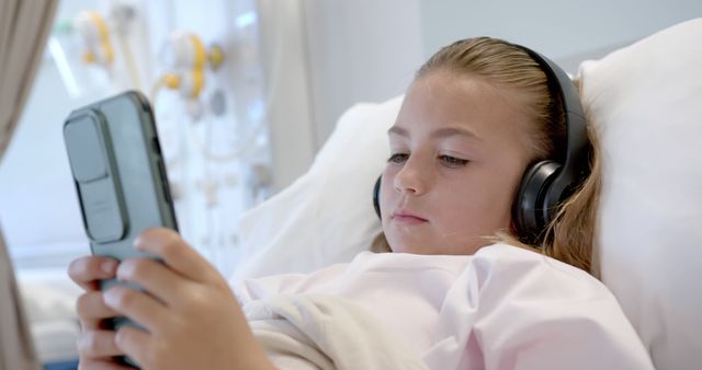 Young Girl in Hospital Bed Using Smartphone and Headphones - Download Free Stock Images Pikwizard.com