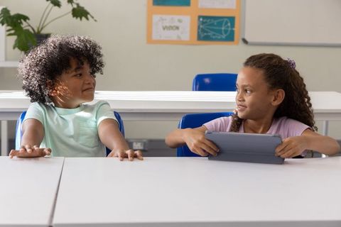 African american children sharing tablet at elementary desk, collaborative learning