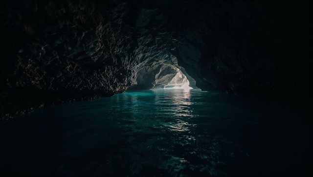 Revealing turquoise grotto with luminescent water reflecting sunlit rock arch