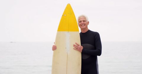 Senior Surfer with Surfboard on Ocean Shore