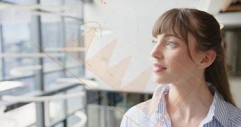 Young professional woman gazing through atrium glass with digital data overlays