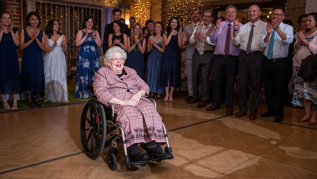Joyful Event: Elderly Woman Enjoying Wedding Reception in Wheelchair
