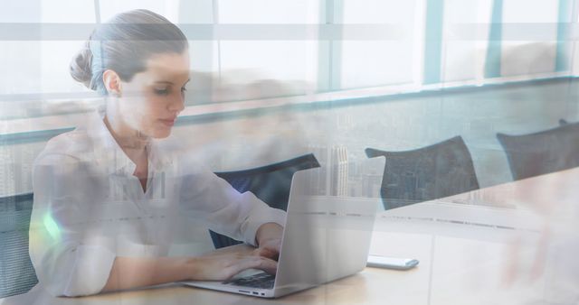 Businesswoman Working on Laptop in Office with Overlapping Cityscape - Download Free Stock Images Pikwizard.com