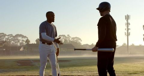Sunrise camaraderie on baseball diamond: diverse teammates shaking hands before practice