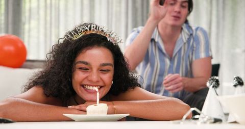 Joyful Couple Celebrating Birthday with Candlelit Cupcake