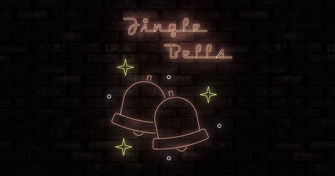 Neon jingle bells on black brick wall