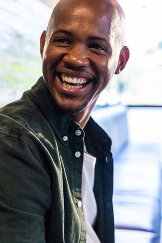 Smiling african man enjoying cafe conversation in warm natural light