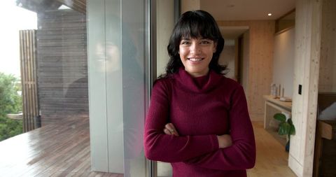Confident Woman at Home Near Floor-to-Ceiling Window