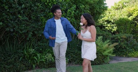Couple enjoying romantic outdoor walk holding flowers