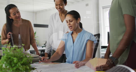 Diverse Female Architects Collaborating on Floor Plans