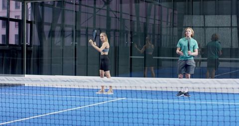 Couple Practicing Paddle Tennis on Modern Blue Court