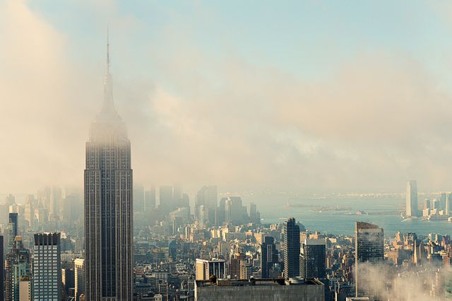 Perfect for websites or blogs focusing on travel, tourism, urban exploration, or architecture. Could be used in promotional material for New York City tourism or as a background for presentations and articles discussing iconic landmarks or city life. The morning fog adds an element of mystery and beauty to the cityscape.