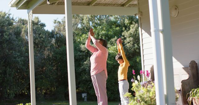 Senior Biracial Grandmother And Grandson Doing Yoga And Meditating On 