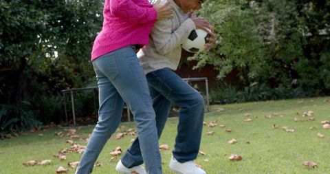 Happy Mother and Son Playing in Autumn Garden