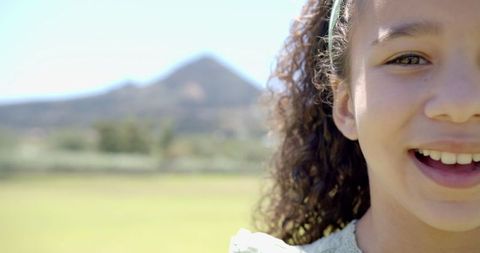Smiling girl enjoying sunny day with mountain view