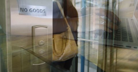 Dynamic Businesswoman Multitasking with Laptop and Workplace Entrance