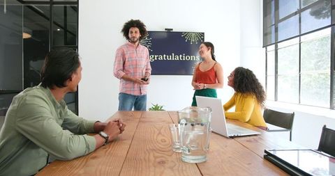 Happy colleagues celebrating achievements in modern office setting
