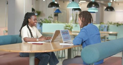 Young African American Colleagues Collaborating on Laptops in Bright Modern Coworking Space