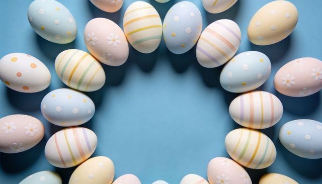 Pastel easter egg wreath forming circle on blue with daisy, stripe and polka patterns
