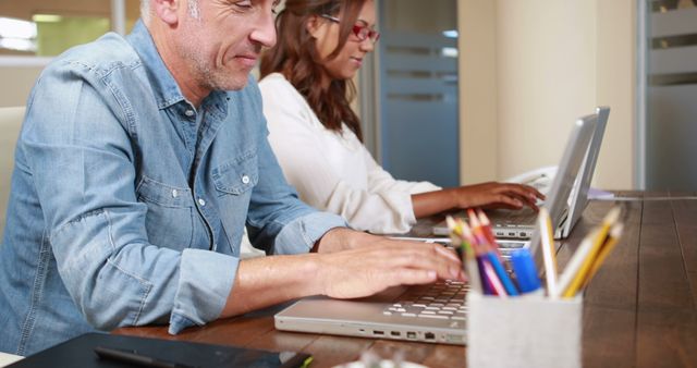 Coworkers Focused on Laptops at Modern Workspace - Download Free Stock Images Pikwizard.com