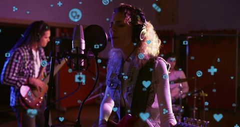Singing woman recording with band in moody studio amid floating social media icons