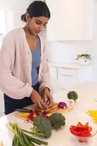 Woman Preparing Vegetables in Modern Home Kitchen Focusing on Healthy Eating