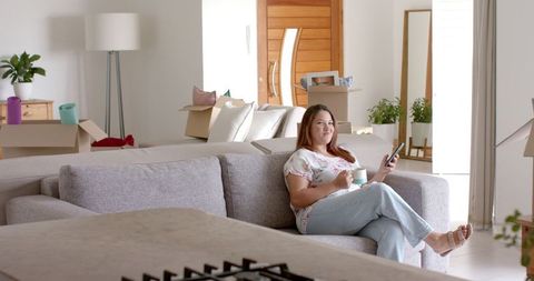 Relaxed Woman Enjoys Coffee and Smartphone in New Home Living Room - Download Free Stock Images Pikwizard.com