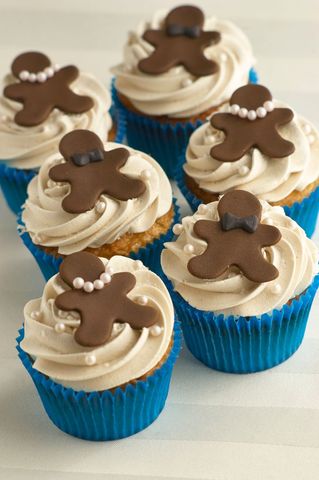 Gingerbread man cupcakes with vanilla frosting in blue holders