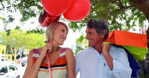 Cheerful Couple Enjoying Shopping Spree with Colorful Bags and Balloons - Download Free Stock Images Pikwizard.com