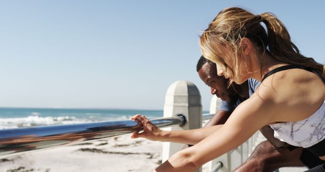 Man and Woman Stretching on Beach Boardwalk with Ocean View - Download Free Stock Images Pikwizard.com