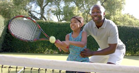 Father and Daughter Tennis Lesson on Outdoor Court