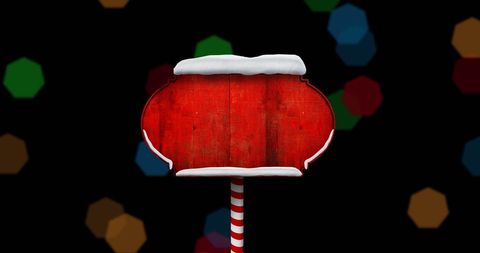 Red Christmas Sign with Snow Detail Against Bokeh Background