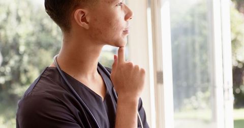 Male Physiotherapist Meditating by Window for Relaxation and Wellness