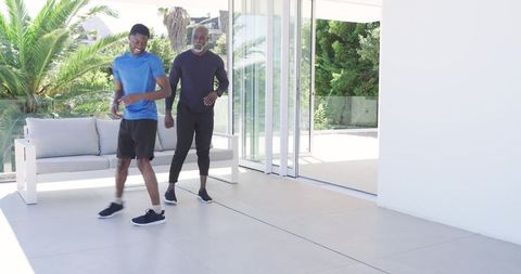 Father and son dynamic exercise on sunny patio