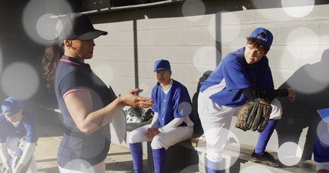 Baseball Coach Motivating Players in Dugout with Outdoor Teamwork