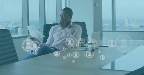 Businessman Analyzing Documents with Digital Media Interface