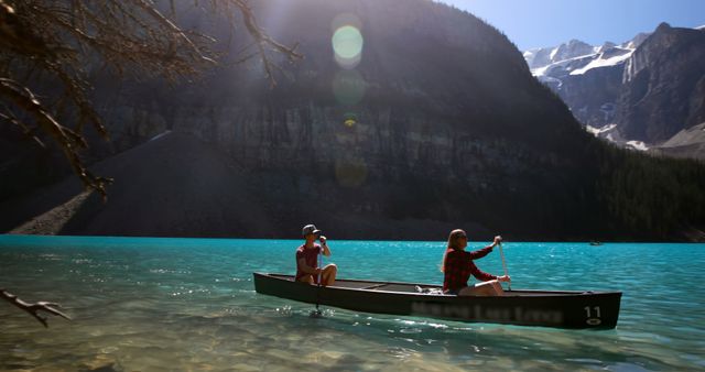 Couple Canoeing on Scenic Mountain Lake Under Clear Sky - Download Free Stock Photos Pikwizard.com