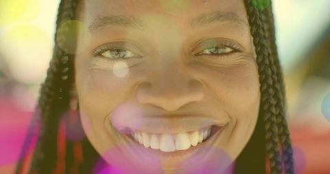 Smiling Woman with Braids and Colorful Lens Flare Effects