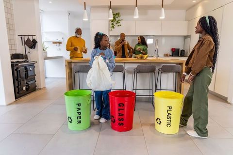 Multigenerational african american family recycling together in modern kitchen