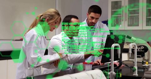 Researchers collaborating over data visualization on computer in modern laboratory wearing lab coats