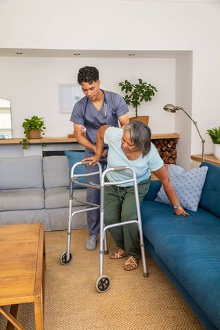 Caregiver Assisting Senior Woman with Mobility Aid in Living Room