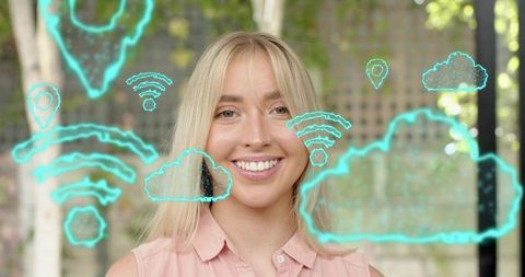 Smiling blonde woman standing with neon cloud and wi-fi icons representing cloud connectivity