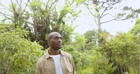 Man embracing nature among lush greenery in tranquil garden