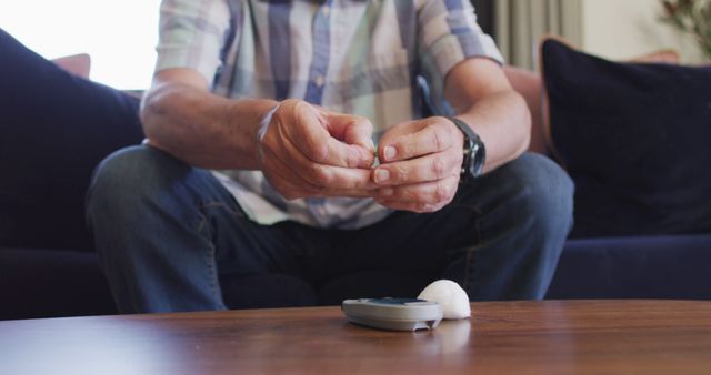 Senior man monitoring blood sugar level with glucometer at home - Download Free Stock Images Pikwizard.com