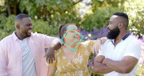 Laughing friends enjoying sunlit garden conversation in casual summer outfits