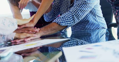 Diverse Team Building Unity with Hands Stacked in Gesture of Collaboration