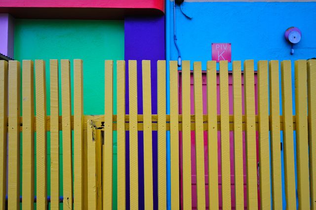 Colorful Urban Fence Against Vibrant Building Walls - Download Free Stock Photos Pikwizard.com