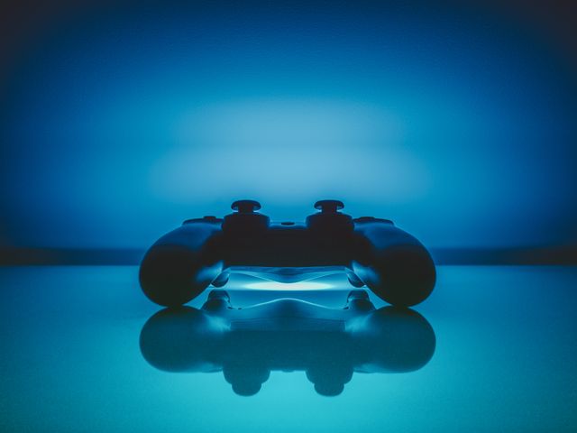 Gaming Controller with Blue Backlight Reflecting on Surface - Download Free Stock Photos Pikwizard.com