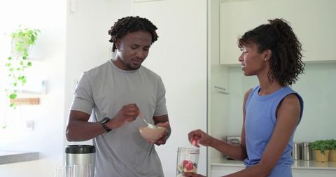 African American Couple Preparing Healthy Fresh Fruit Smoothie in Bright Minimalist Kitchen